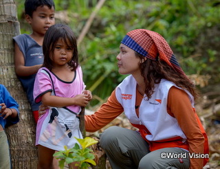 2013年フィリピンを直撃した大型台風で被災した子どもの声に耳を傾けるスタッフ