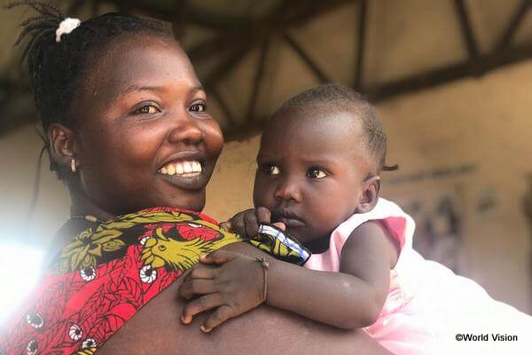 南スーダン難民危機により大学に通うことが難しくなってしまった、生後9か月の娘を抱く女性