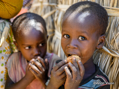 食糧不足のためヤシの実をかじるケニアの子どもたち