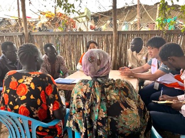 南スーダン・ジュバのWFPプロジェクトの避難民キャンプで暮らす受益者へインタビューをする内藤スタッフ