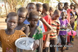 ケニアのカクマ難民キャンプで朝食のおかゆを受け取るために並んでいる、南スーダンから逃れてきた子どもたち(2014年1月)