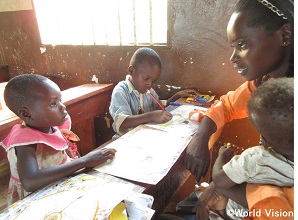 ウガンダの現地スタッフが子どもたちに手紙の書き方を教えている様子